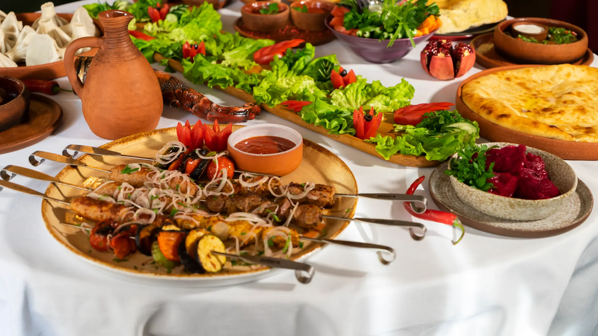 Lebanese catering table with kabobs, bread, salads, and dips